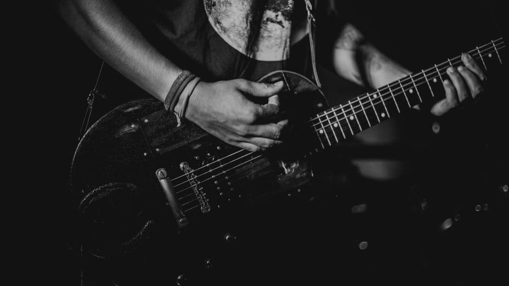 man holding and playing a guitar