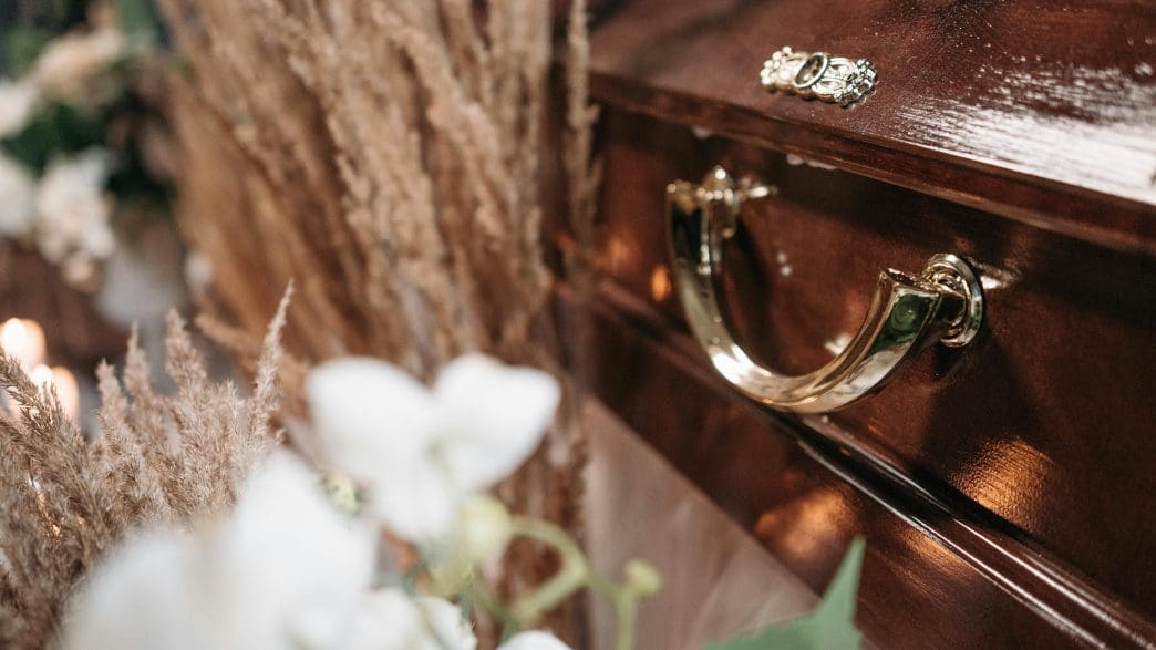 funeral casket with flowers on top