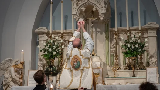 priest at Catholic funeral offering holy communion