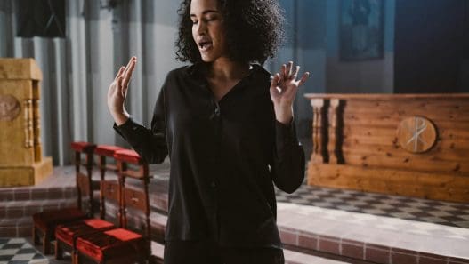woman in black long sleeves standing near the altar