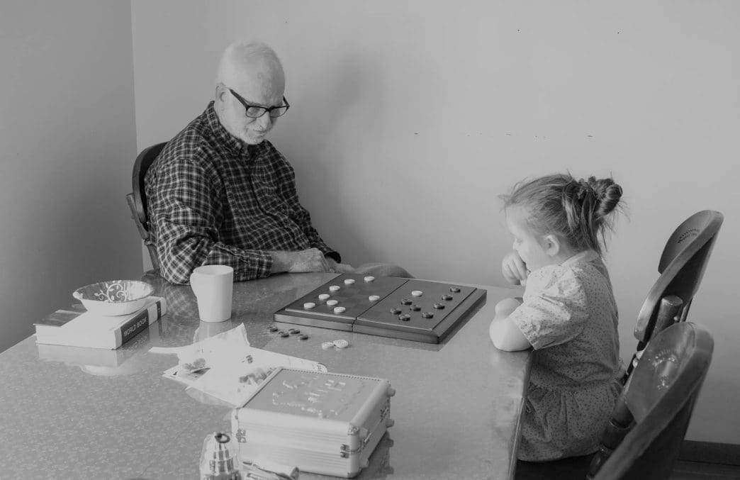 man and little girl playing checkers