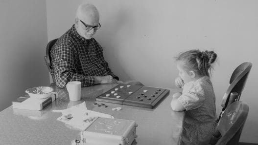 man and little girl playing checkers
