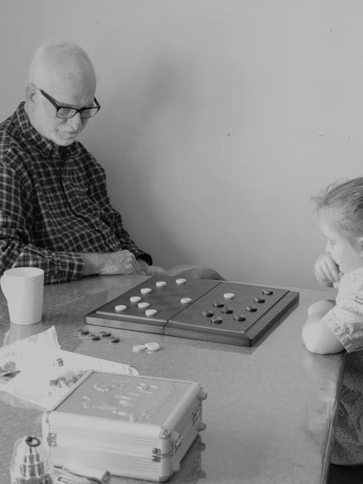man and little girl playing checkers