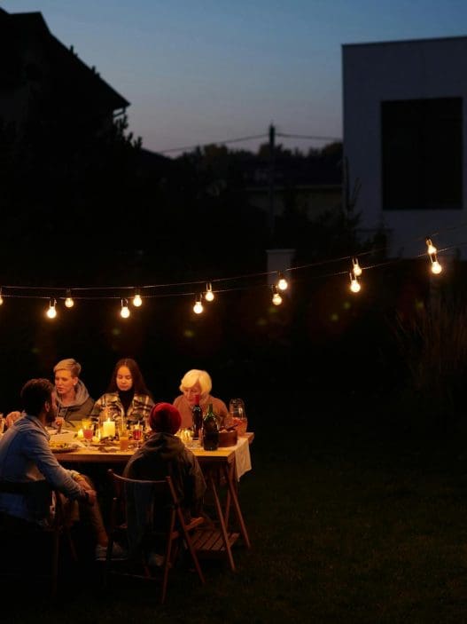 family sitting by table at garden