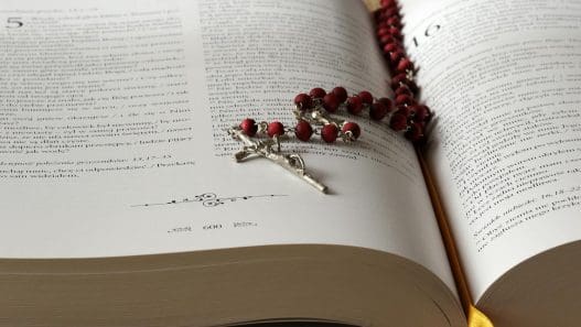 rosary on top of opened bible book