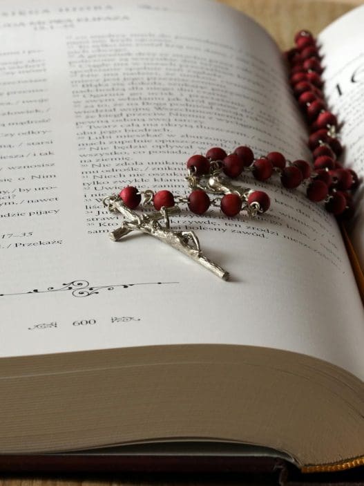 rosary on top of opened bible book