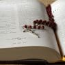 rosary on top of opened bible book