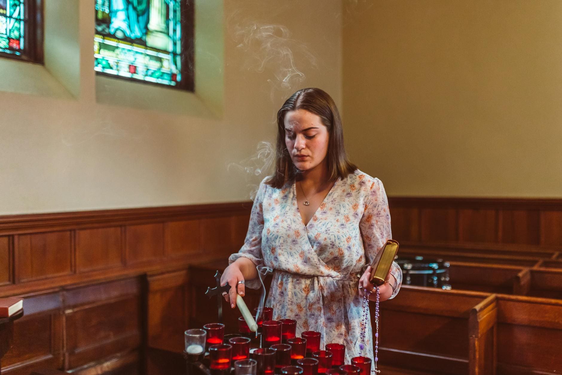 woman inside the church lighting up the candle