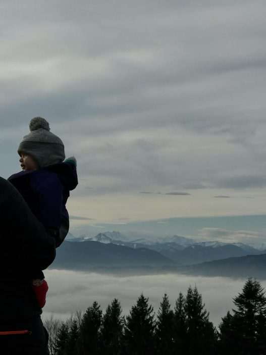 man holding a baby in a mountain landscape