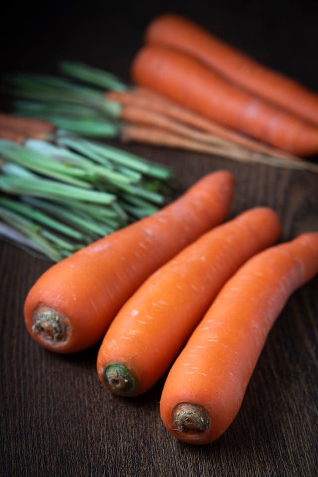 close up image of carrots on a wooden table