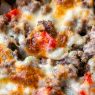 close up of baked beef cheesesteak casserole in skillet